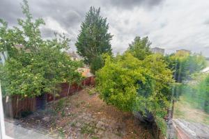 a view of a garden with trees and a fence at Beautiful 4 bedroom house with free parking Luton in Luton