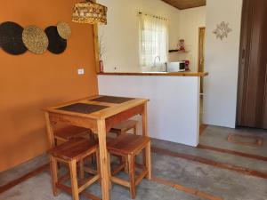 eine Küche mit einem Holztisch und 2 Hockern in der Unterkunft San Nicolas Residêncial in São Bento do Sapucaí
