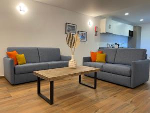 a living room with two couches and a coffee table at Kuanza Nature Experience, Fajã do Belo in Fajã da Caldeira de Santo Cristo