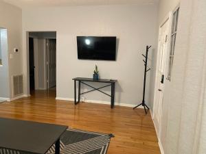 a living room with a table and a television on a wall at Cozy house with large free parking on premises in Springfield