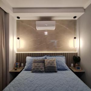 1 dormitorio con 1 cama con cabecero grande en Conforto com ar, tvs smart, na quadra da praia do Forte, em frente Praça da Cidadania, en Cabo Frío