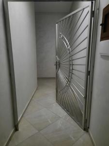 een metalen deur in een kamer met een tegelvloer bij اقامة البحتوري in Nador