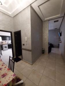 een kamer met een keuken en een woonkamer met een tafel bij اقامة البحتوري in Nador