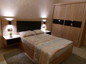 een slaapkamer met een groot bed en 2 nachtkastjes bij اقامة البحتوري in Nador