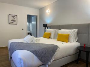 a bedroom with a large bed with yellow pillows at Kuanza Nature Experience, Fajã do Belo in Fajã da Caldeira de Santo Cristo