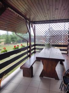 スピホボにあるCichy Zakątek Nad Krutyniąの木製のテーブルとベンチ付きのポーチ