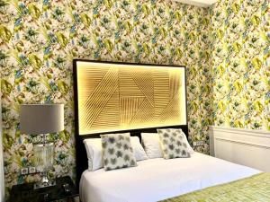 a bedroom with a white bed and a floral wallpaper at Hotel Royal Suite Santander in Santander