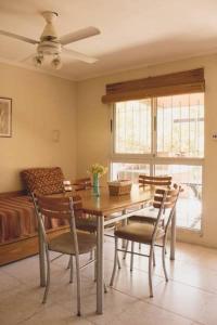 a dining room with a table and chairs and a bed at Los Arboles in Villa Urquiza