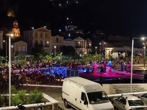 a large group of people in a city at night at Main square apartment in Symi