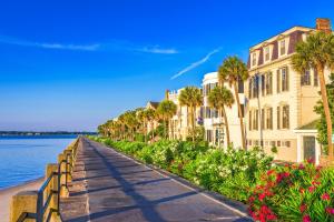 a walkway in front of buildings next to the water at Beautiful Historic Downtown Charleston Home in Charleston
