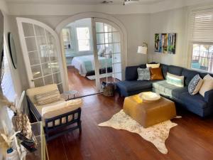 a living room with a blue couch and a bed at Beautiful Historic Downtown Charleston Home in Charleston