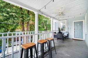 a porch with stools and a ceiling fan at Beautiful Historic Downtown Charleston Home in Charleston