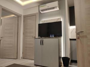 un soggiorno con TV e armadietto bianco di 46m luxury room near downtown and all services ad Amman