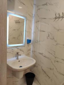 bagno bianco con lavandino e specchio di 46m luxury room near downtown and all services ad Amman