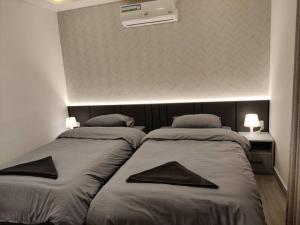 dwa łóżka siedzące obok siebie w pokoju w obiekcie 46m luxury room near downtown and all services w mieście Amman