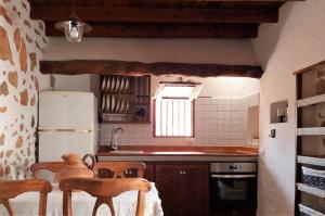 a kitchen with a refrigerator and a table and chairs at Casa antigua en el centro de Fuerteventura in Antigua