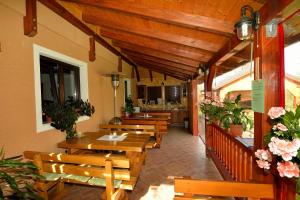 a restaurant with wooden tables and benches and flowers at Guest House Ljubo & Ana in Rastovača