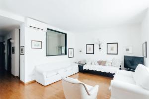 een witte woonkamer met witte banken en een tv bij La casa di Isa in Lecco