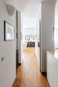uma sala de estar com paredes brancas e piso em madeira em La casa di Isa em Lecco