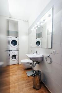 een badkamer met een wastafel, een toilet en wasmachines bij La casa di Isa in Lecco