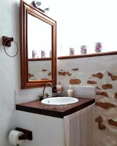 y baño con lavabo y espejo. en Casa antigua en el centro de Fuerteventura, en Antigua