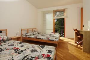a bedroom with two beds and a window with a window at Pizzo Cane House camera con bagno e piscina in Altavilla Milicia