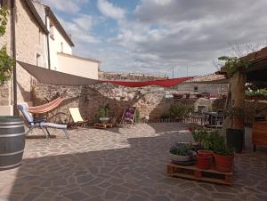 un patio con sillas, macetas y una pared de piedra. en Inma Enea, en Armañanzas