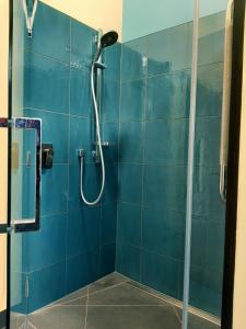 baño con ducha y pared de azulejos azules en Kotare BandB en Geraldine