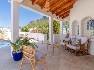 a patio with chairs and a table and a plant at Scenic Villa, Costa Blanca in Denia
