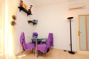 a dining room with purple chairs and a glass table at Apartments with WiFi Dubrovnik - 4681 in Dubrovnik