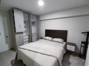 1 dormitorio con 1 cama grande con sábanas blancas en Epiqe Manuel Olguin 600 en Lima