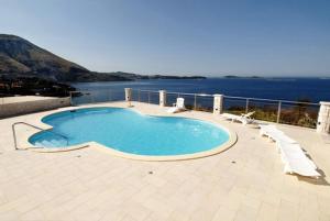 a large swimming pool with chairs and the water at Apartments with a swimming pool Soline, Dubrovnik - 4762 in Mlini
