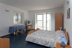 a bedroom with a bed and a table and a television at Apartments with a swimming pool Soline, Dubrovnik - 4762 in Mlini