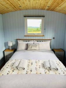 a bedroom with a bed with two towels on it at Bespoke luxury huts with hot tubs. Located in the black mountains. in Llanveynoe