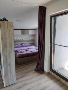 ein Schlafzimmer mit einem Bett und einem großen Fenster in der Unterkunft Zen Studio Slatina in Slatina