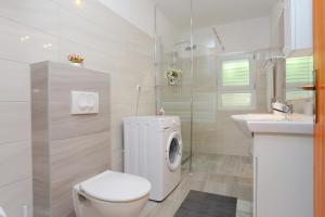 a white bathroom with a toilet and a sink at Apartments with a parking space Nemira, Omis - 4652 in Tice