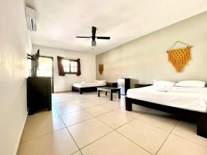 a large room with two beds and a couch at We playa Hotel-Hostel in Playa del Carmen