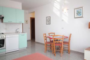 a kitchen with a table and chairs in a room at Apartments by the sea Medveja, Opatija - 3430 in Medveja