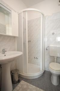 a bathroom with a shower and a toilet and a sink at Apartments by the sea Medveja, Opatija - 3430 in Medveja