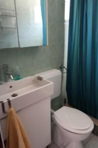 a bathroom with a white toilet and a blue shower curtain at Apartments by the sea Businci, Ciovo - 4668 in Trogir