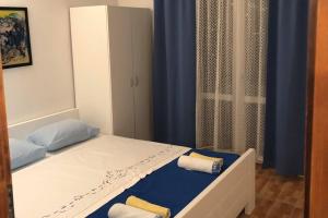 a small bedroom with a bed with blue curtains at Apartments by the sea Businci, Ciovo - 4668 in Trogir