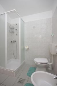 a bathroom with a shower and a toilet and a sink at Apartment Nerezine 3451c in Nerezine