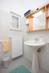 a bathroom with a sink and a mirror at Apartment Nerezine 3451c in Nerezine