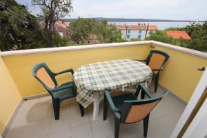 a table and chairs on a balcony with a table at Apartment Nerezine 3451c in Nerezine