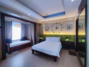 ein Schlafzimmer mit einem Bett und einer Uhr an der Wand in der Unterkunft TWO PALMTREE VILLAS NEWPORT BOULEVARD NEAR NAIA 3 PASAY CITY in Manila