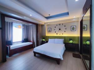 a bedroom with a bed and a clock on the wall at TWO PALMTREE VILLAS NEWPORT BOULEVARD NEAR NAIA 3 PASAY CITY in Manila +15 photos