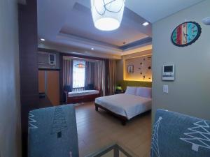ein Schlafzimmer mit einem Bett und einem Sofa in einem Zimmer in der Unterkunft TWO PALMTREE VILLAS NEWPORT BOULEVARD NEAR NAIA 3 PASAY CITY in Manila