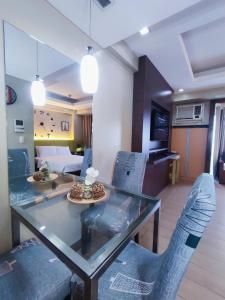 ein Esszimmer und ein Wohnzimmer mit einem Glastisch und Stühlen in der Unterkunft TWO PALMTREE VILLAS NEWPORT BOULEVARD NEAR NAIA 3 PASAY CITY in Manila