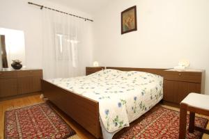- une chambre avec un lit et un tapis dans l'établissement Apartments with WiFi Trsteno, Dubrovnik - 4746, à Trsteno
