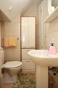 La salle de bains blanche est pourvue de toilettes et d'un lavabo. dans l'établissement Apartments with WiFi Trsteno, Dubrovnik - 4746, à Trsteno